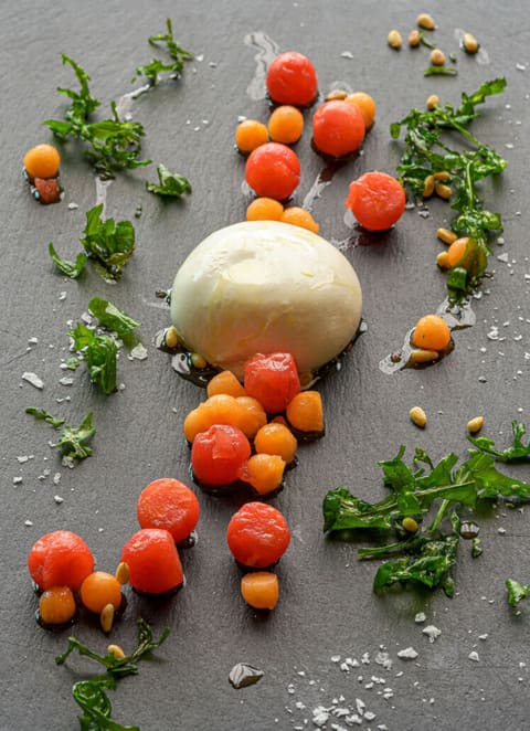 Burrata mit Kirschtomaten, Melone und Kräutern