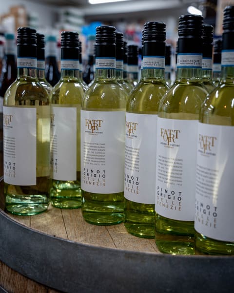 Italienische Weißweine auf einem Weinfass in der Vinothek